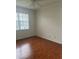 Bright bedroom with hardwood floors, ceiling fan, and a window with natural light at 5480 Summerland Hills Dr, Lakeland, FL 33812