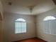 Charming dining room with hardwood floors, two arched windows, and an elegant chandelier at 5480 Summerland Hills Dr, Lakeland, FL 33812