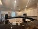 Well-lit kitchen featuring white cabinets, black countertops, and modern stainless steel appliances at 5480 Summerland Hills Dr, Lakeland, FL 33812