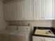 Bright laundry room equipped with white cabinets, sink and countertop, and washer and dryer hookups at 5480 Summerland Hills Dr, Lakeland, FL 33812
