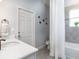 Bathroom with modern sink, bathtub, and shower with white door and accents at 561 Silver Course Run, Ocala, FL 34472