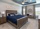 Spacious bedroom with a tray ceiling, a large bed, and well-coordinated decor and natural light at 561 Silver Course Run, Ocala, FL 34472