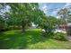 Expansive backyard with lush green lawn, mature trees, and a privacy fence, offering plenty of space for outdoor activities at 5619 Stratford Ln, Lakeland, FL 33813