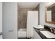 Modern bathroom featuring gray tile shower and granite sink with wood framed mirror at 5619 Stratford Ln, Lakeland, FL 33813