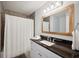 Nicely renovated bathroom with stone tile, framed mirror, and granite vanity top at 5619 Stratford Ln, Lakeland, FL 33813