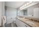 Bright bathroom featuring double sinks, granite countertop, stylish vanity and a shower at 5619 Stratford Ln, Lakeland, FL 33813