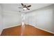 Bedroom with hardwood floors has a closet, fan, and an open door leading to another room at 5619 Stratford Ln, Lakeland, FL 33813