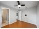 Neutral bedroom with hardwood floors, a ceiling fan, and an ensuite bathroom at 5619 Stratford Ln, Lakeland, FL 33813