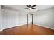Bedroom with hardwood floors features a ceiling fan and large closet for storage at 5619 Stratford Ln, Lakeland, FL 33813