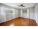 Bright bedroom features hardwood floors, modern ceiling fan, and ample natural light from windows at 5619 Stratford Ln, Lakeland, FL 33813