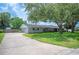 Charming one-story home with a well-maintained lawn, a long driveway leading to a garage, and mature trees in the front yard at 5619 Stratford Ln, Lakeland, FL 33813
