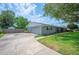 Charming one-story home with a well-maintained lawn, a long driveway leading to a garage, and mature trees in the front yard at 5619 Stratford Ln, Lakeland, FL 33813