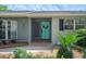 Inviting front entrance with a bright turquoise door, lush plants and updated fixtures at 5619 Stratford Ln, Lakeland, FL 33813