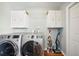 Functional laundry room featuring a washer, dryer, white cabinets, and storage solutions at 5619 Stratford Ln, Lakeland, FL 33813