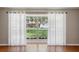 Sun-filled living room with hardwood floors and large window with sheer curtains at 5619 Stratford Ln, Lakeland, FL 33813
