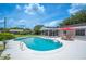 Inviting backyard pool with a spacious deck, an umbrella-shaded table, and a screened lanai at 5619 Stratford Ln, Lakeland, FL 33813