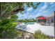 Inviting in-ground pool with a hammock and umbrella-covered patio area, perfect for relaxation and outdoor entertaining at 5619 Stratford Ln, Lakeland, FL 33813