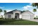 Charming single-story home featuring a well-manicured lawn, an arched entryway, and an attached two-car garage at 563 Silver Course Radl, Ocala, FL 34472