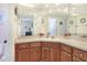 Bright bathroom vanity featuring wood cabinets, a light countertop, and decorative mirrors at 5857 Macaw Pl, Lakeland, FL 33809