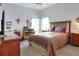 Spacious bedroom with neutral tones, featuring a comfortable bed, desk, and ample natural light at 5857 Macaw Pl, Lakeland, FL 33809