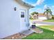 Exterior view of the home's side door, landscaping, and a glimpse of the front yard at 5857 Macaw Pl, Lakeland, FL 33809