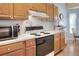 Well-lit kitchen with wood cabinets, white countertops, and black appliances offers a functional cooking space at 5857 Macaw Pl, Lakeland, FL 33809
