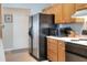 Kitchen featuring stainless steel refrigerator and microwave, complemented by wood cabinets and white door at 5857 Macaw Pl, Lakeland, FL 33809