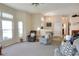 Cozy living room with plush carpeting, neutral walls, ceiling fan and natural light from the large arched window at 5857 Macaw Pl, Lakeland, FL 33809