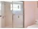 Bathroom shower featuring decorative glass doors and tiled walls with a window at 5857 Macaw Pl, Lakeland, FL 33809