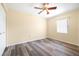 Bright bedroom featuring a ceiling fan, wood-look floors, and a window for natural light at 6001 Condor Dr, Lakeland, FL 33809