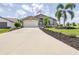 Inviting single-story home with a two-car garage, manicured lawn, and a decorative palm tree at 6001 Condor Dr, Lakeland, FL 33809