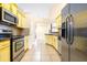 Well-equipped kitchen featuring stainless steel appliances and yellow cabinets at 6001 Condor Dr, Lakeland, FL 33809