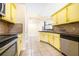 The kitchen features a stainless steel dishwasher and bright yellow cabinets at 6001 Condor Dr, Lakeland, FL 33809