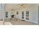 Covered back porch featuring a grill, seating, concrete floor, exterior doors and a double ceiling fan at 619 Somerset Loop, Auburndale, FL 33823