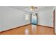 Bright bedroom with a ceiling fan, hardwood floors, a window, and an open doorway to another room at 619 Somerset Loop, Auburndale, FL 33823