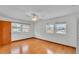 Bright bedroom with three windows, ceiling fan, and wood-look flooring at 619 Somerset Loop, Auburndale, FL 33823