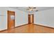 Simple bedroom with hardwood floors, a ceiling fan, and two doors, offering a clean and functional space at 619 Somerset Loop, Auburndale, FL 33823