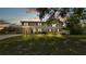 Home exterior with large front lawn at sunset at 619 Somerset Loop, Auburndale, FL 33823