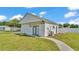Garage featuring white siding, green trim, concrete pathway, and well-maintained lawn in a residential neighborhood at 619 Somerset Loop, Auburndale, FL 33823