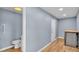 Bright hallway features wood-look flooring, access to bathroom, and stacked washer/dryer at 619 Somerset Loop, Auburndale, FL 33823