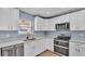 Bright kitchen featuring white cabinets, stainless appliances, and natural wood flooring at 619 Somerset Loop, Auburndale, FL 33823