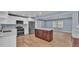 Open kitchen layout with stainless steel appliances and a large island, connected to living area at 619 Somerset Loop, Auburndale, FL 33823