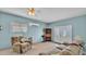 Cozy living space with sofas, ceiling fan, and access to outdoor views through glass doors at 619 Somerset Loop, Auburndale, FL 33823