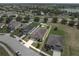 Aerial view of a home with a white fenced yard, showing neighborhood and lake views at 647 Chicago Way, Dundee, FL 33838