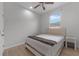 Bright bedroom features neutral color palette, large window, ceiling fan, and light colored wood flooring at 647 Chicago Way, Dundee, FL 33838