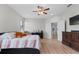 Bright bedroom featuring wood-look flooring, ceiling fan and contemporary furnishings at 647 Chicago Way, Dundee, FL 33838