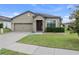 Charming one-story home showcasing a well-manicured lawn, tidy landscaping, and inviting curb appeal at 647 Chicago Way, Dundee, FL 33838