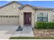 Inviting home featuring a covered entry, stylish front door, and low-maintenance landscaping at 647 Chicago Way, Dundee, FL 33838