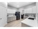 Well-lit kitchen featuring modern appliances, white cabinets, grey countertops, and wood-style flooring at 647 Chicago Way, Dundee, FL 33838