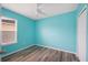 Bedroom with wood-look flooring, ceiling fan, window, and closet at 6819 Glenbrook Dr, Lakeland, FL 33811